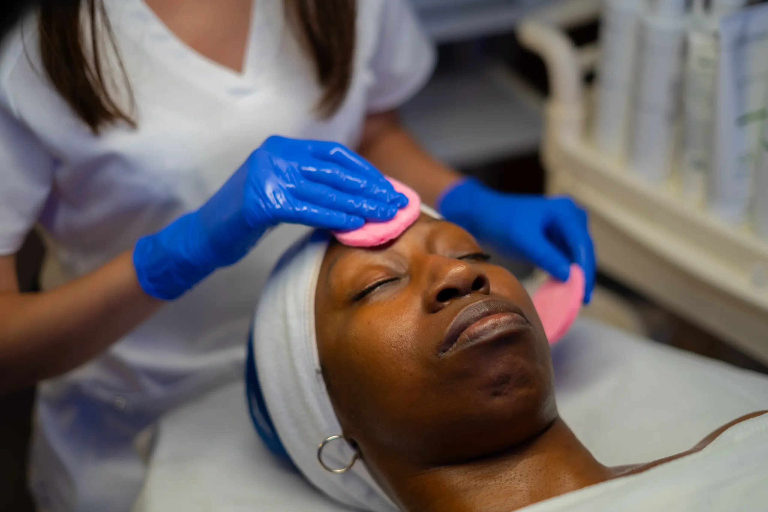 Aesthetician performing gentle exfoliation as part of a facial at AryNova Aesthetics Mount Prospect