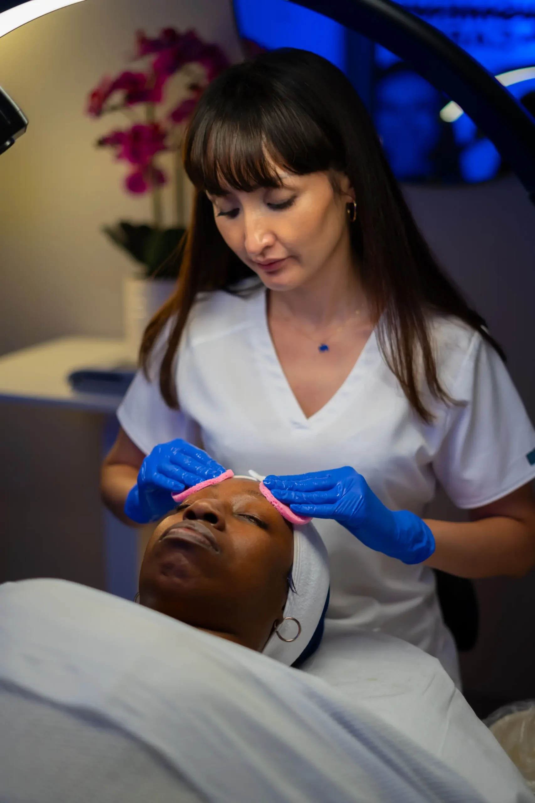Aesthetician performing a hydrating cleansing facial on a patient at AryNova Aesthetics